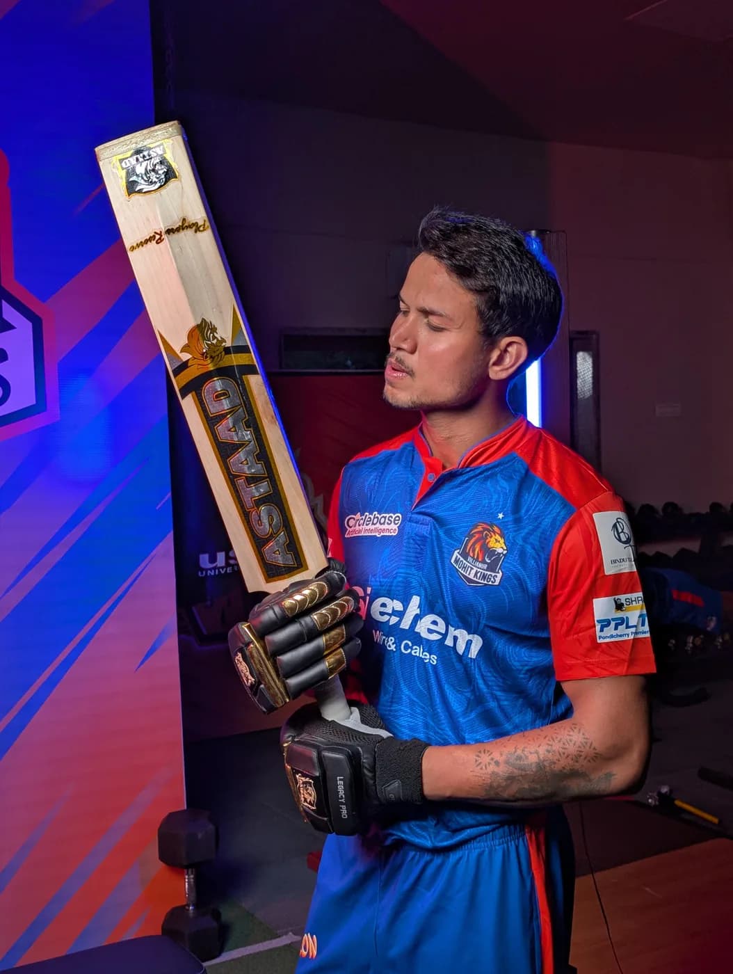 A batter in a team jersey holding an Astaad bat