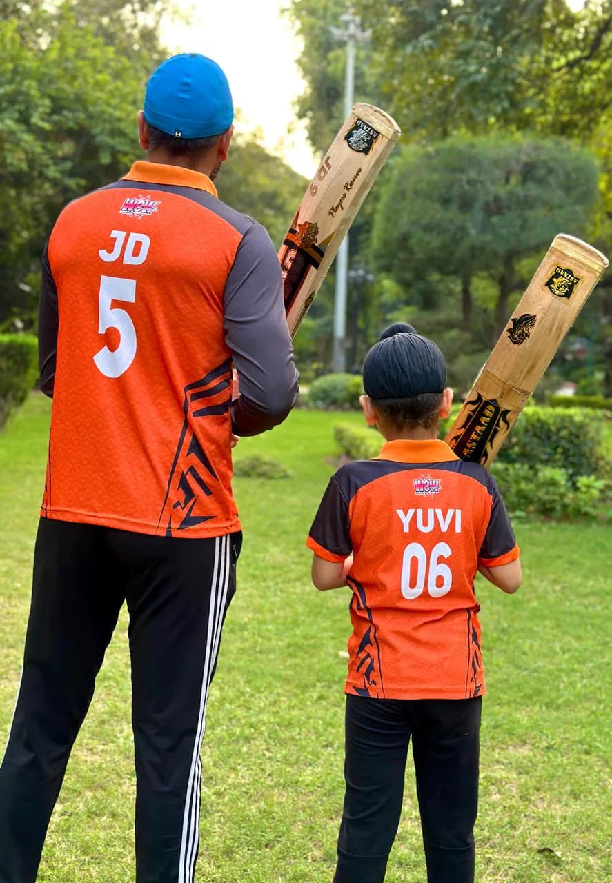 Two players in matching jerseys holding Astaad bats