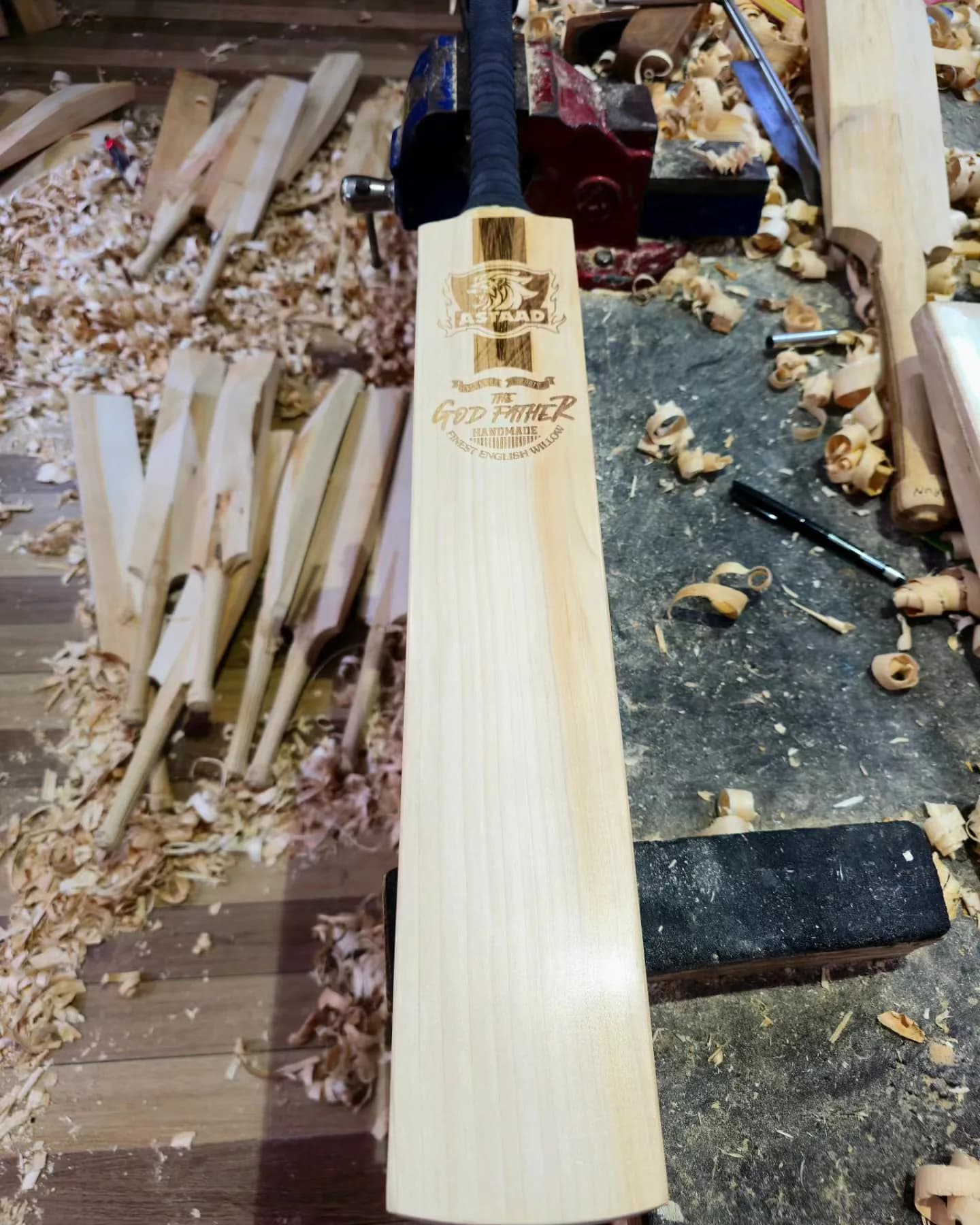 A finished Astaad bat on the workbench among wood shavings